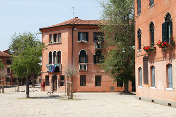 Small park in Venice. Hot, bright shadows, old houses painted in ochre