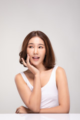 Beautiful Asian young woman touching soft cheek smile with clean and fresh skin Happiness and cheerful with positive emotional,isolated on gray background,Beauty and Cosmetics Concept