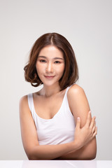 Beautiful Young Asian Woman with short hairs Touching Shoulder feeling so happy and cheerful with healthy Clean and Fresh skin,isolated on gray background,Beauty Cosmetology Concept