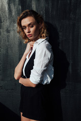 Fototapeta premium Beautiful fashionable blonde woman in white blouse and black shorts with boots