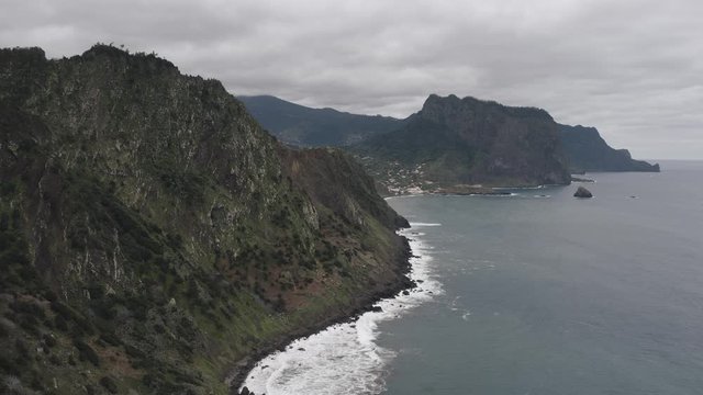 Aerial view flying over coastline rocks and mountains in Madeira. 