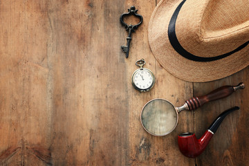 Concept image of investigation or private detective. Fedora hat, magnifing glass and vintage items...