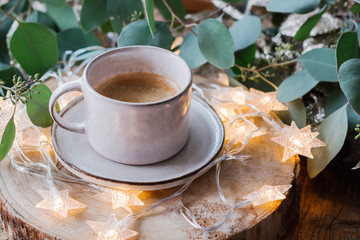 Warm and cosy hygge background with coffee and lights.