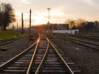 Fototapeta na wymiar Railway at sunset. Railway station against at sunset. Industrial landscape with a railway. Railway junction. Heavy industry. Evening on the road