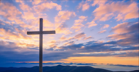 Cross on a mountain top with beautiful sunset sky