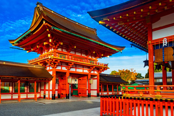 Japan. Kyoto. The Fushimi Inari Shrine. Fushimi Inari Taisha Temple. The Mountain Of Inariyama. The temple in honor of the goddess Inari. Shinto. Mythology. Orange pagoda on the background of blue sky