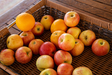 apples and oranges in a wicker basket