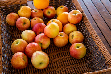 Naklejka na ściany i meble apples and oranges in a wicker basket