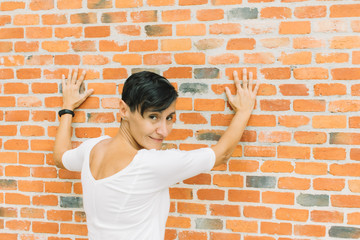 middle-aged woman with from the back with hands on wall