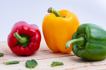 Colorful peppers placed on a wooden table.