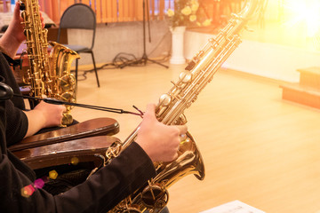 Hand of musician playing jazz saxophone during live performance on stage