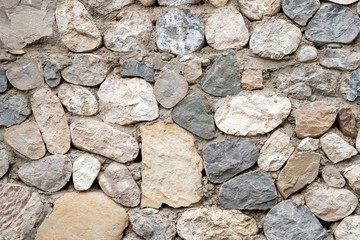 the wall of stones monotonous color of different sizes and shapes