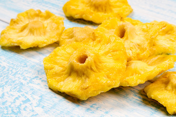 Pineapple dried round slices on blue and white wooden background