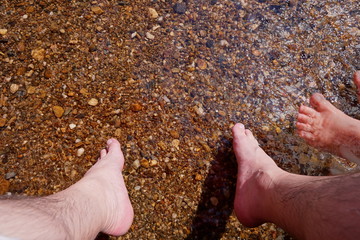 Relaxing Time , Foot playing water with small brown stone and gravel under water at shallow river