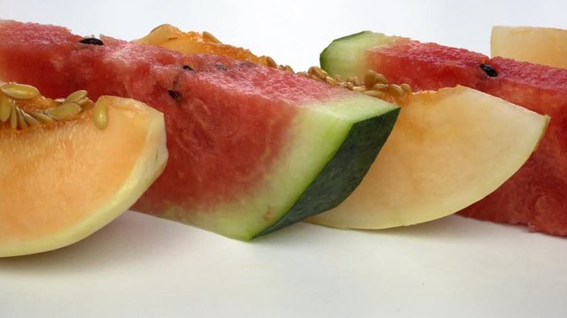 Juicy sliced ​​melon and watermelon on a white background. Slices are on the table.