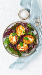 Cyprus fried halloumi with salad mix, beet tops. Lchf, pegan, fodmap, paleo, scd, keto, ketogenic diet. Balanced food, clean eating recipe. Top view, white background, vertical