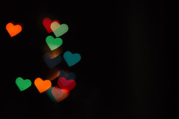 Multicolored heart - shaped lights on the black background