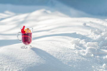 Cup with delicious mulled wine and spices on a snow covered, Valentines Day greeting card