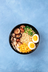 Ramen noodle soup. Soba with eggs, shiitake and enoki mushrooms, sweetcorn and scallions, shot from above with copy space