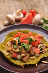 Vegetarian / Vegan Crepes stuffed witg vegetable on wooden table.