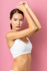 Fototapeta premium Health body concept. young attractive woman with perfect body stand wearing white sports undewear isolated on pink background