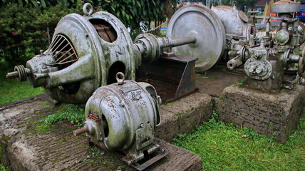 A statue of a tea leaf processing machine monument in a park on a mountain
