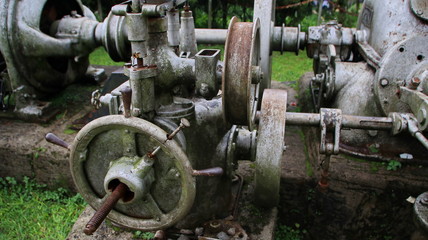 A statue of a tea leaf processing machine monument in a park on a mountain