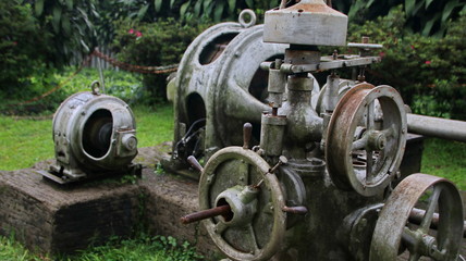 A statue of a tea leaf processing machine monument in a park on a mountain