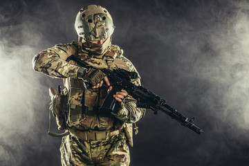 military, army, soldiers concept. brave young soldier prepare to attack holding gun in white foggy space