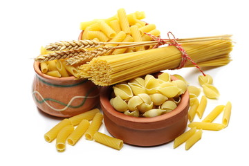 Conchiglie grandi, penne rigate and tortiglioni pasta in clay pot, bowl with spaghetti bundle isolated on white background