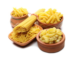 Conchiglie grandi, penne rigate and tortiglioni pasta in clay pot, bowl with spaghetti bundle isolated on white background