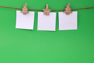 A garland of white empty leaves hanging on a rope on wooden clothespins with Christmas theme on a...