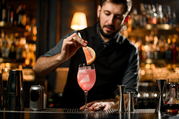 Bartender adding grapefruit slice in a drink