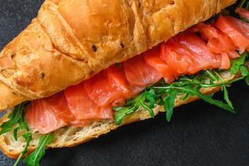 fish sandwich and greens, Smorrebrod (salted salmon, croissant, bread, arugula and other ingredients) menu concept. food background. top view. copy space