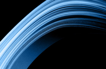 Macro photo of bright wavy paper tapes on isolated black background. Abstract modern background in trendy blue color. Mockup for your design. Color of the year 2020 concept. Futuristic concept.