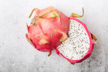 Exotic dragon fruit cut in half on grey stone background