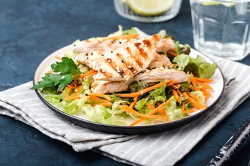 The concept of healthy diet. White grilled chicken meat with lettuce leaves on a plate