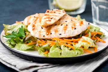 The concept of healthy diet. White grilled chicken meat with lettuce leaves on a plate