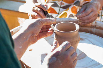 Fototapeta na wymiar hands of potter creating glass jar