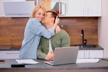 young caucasian woman and man had successful discussion of purchase, taking mortgage together, online checking at home using laptop