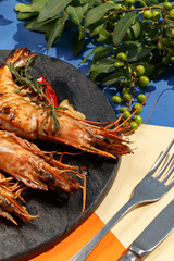 Exquisite dish, king prawns on a black slate plate. Restaurant serve.