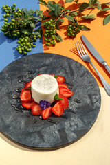 Exquisite dish, strawberry cream dessert on a black slate plate. Restaurant serve.