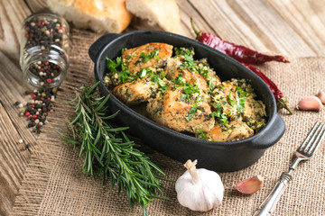 Baked chicken in garlic sauce with cilantro, herbs and spices on a rustic background. Chkmeruli is a traditional dish of Caucasian Georgian cuisine.