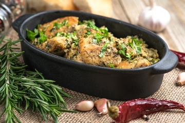 Baked chicken in garlic sauce with cilantro, herbs and spices on a rustic background. Chkmeruli is a traditional dish of Caucasian Georgian cuisine.