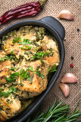 Baked chicken in garlic sauce with cilantro, herbs and spices on a rustic background. Chkmeruli is a traditional dish of Caucasian Georgian cuisine.