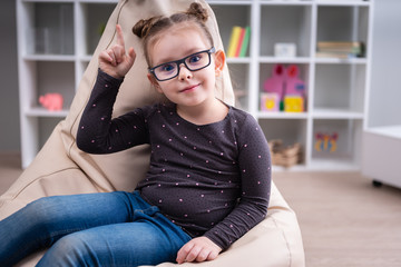 Fototapeta premium Beauty little girl in the home finger up