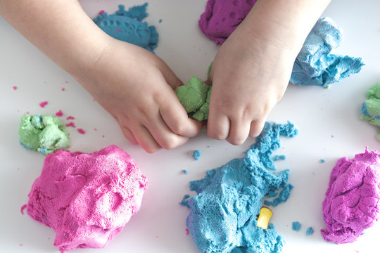 Colorful molded plasticine and childrens hands clay isolated on white background