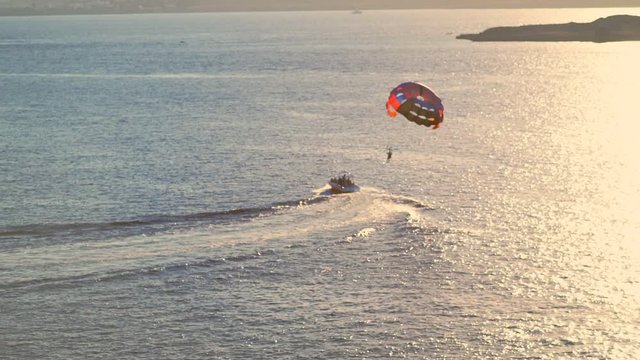 Speedboat towing a person under a parachute