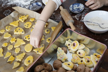 Kleines Mädchen backt und dekoriert Weihnachtsplätzchen