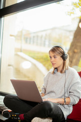 Young female freelancer.  Beautiful businesswoman working and listening music. 